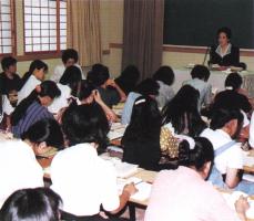 Young adults listen to a lecture by the director.